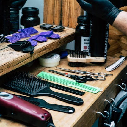Professional barber tools including clippers, combs, and brushes neatly arranged at Tru Hair Studio barbershop in Brighton, Colorado.