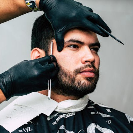 Skilled barber shaping a beard with precision scissors at Tru Hair Studio, delivering clean beard trims and men’s grooming in Brighton, Colorado.