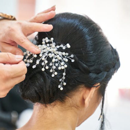 Professional hairstylist finishing an elegant bridal updo with decorative accessories at Tru Hair Studio in Brighton, CO.