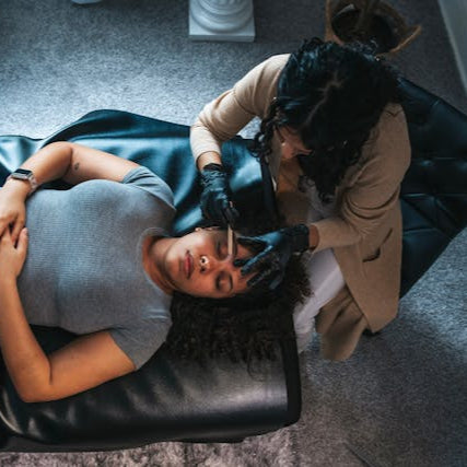 Professional stylist performing eyebrow waxing for a client at Tru Hair Studio in Brighton, Colorado.