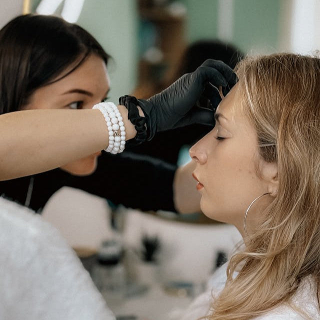 Professional stylist performing eyebrow waxing for a client at Tru Hair Studio in Brighton, Colorado