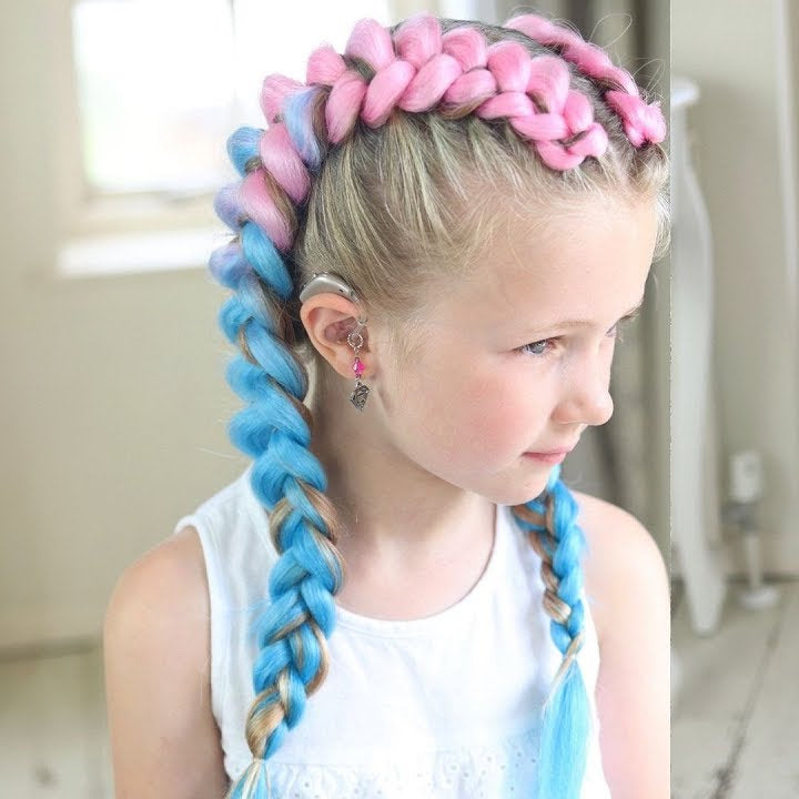 Young girl with pink and blue braided hairstyle at Tru Hair Studio in Brighton, Colorado, offering kids’ braiding and creative hair designs.