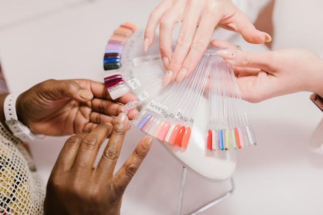 Clients selecting from a variety of nail polish colors and designs at Tru Hair Studio in Brighton, Colorado.
