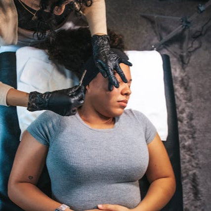 Close-up of stylist shaping eyebrows with waxing technique at Tru Hair Studio in Brighton, Colorado.